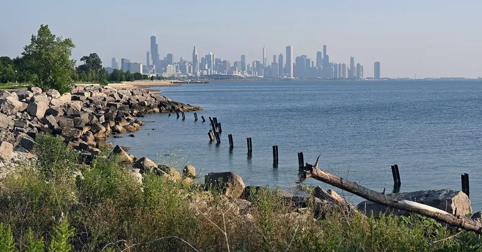 The Chicago skyline across Lake Michigan, seen from a rocky lakefront shore